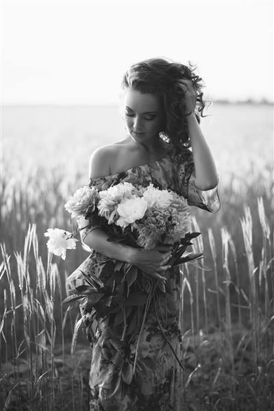 دختری با دسته گل در غروب آفتاب عکس سیاه و سفید