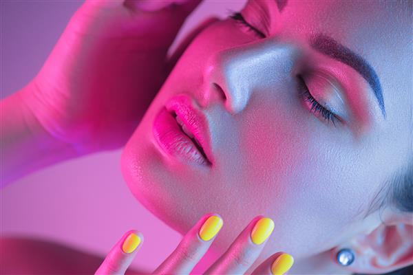 دختر مدل مد بالا با نورهای رنگارنگ روشن UV در استودیو