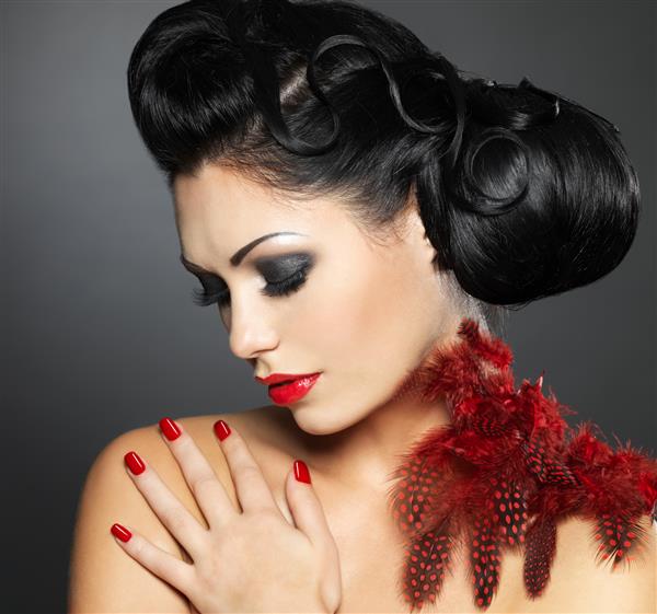 زن جوان مد با ناخن های قرمز مدل موهای خلاقانه و آرایش