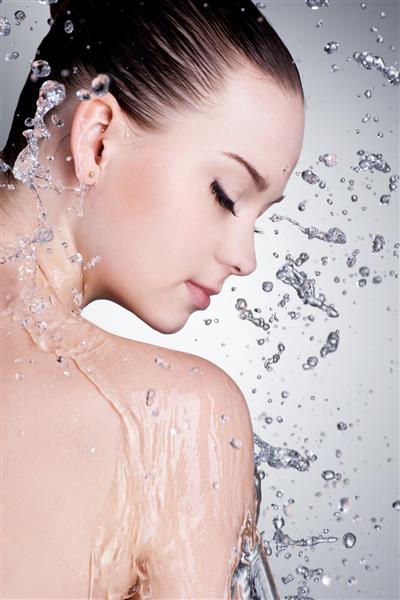 پاشیدن و قطرات آب در اطراف صورت زن با پوست تمیز - عمودی