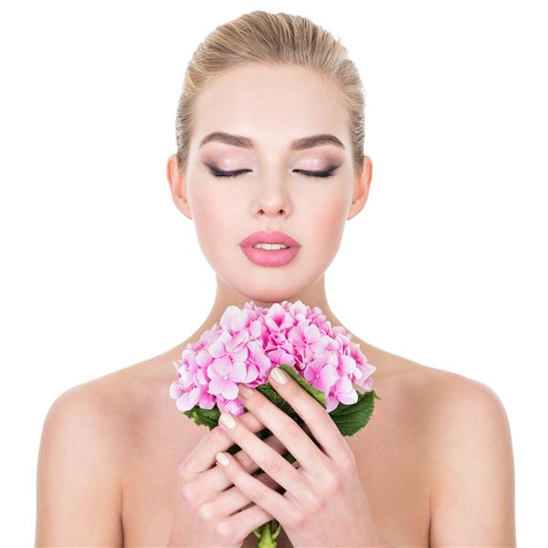 زن جوان زیبا با گل های نزدیک صورت