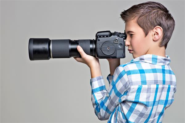 پسر نوجوان با دوربین dslr عکاسی می کند پسری با دوربین در حال عکس گرفتن پرتره پروفایل