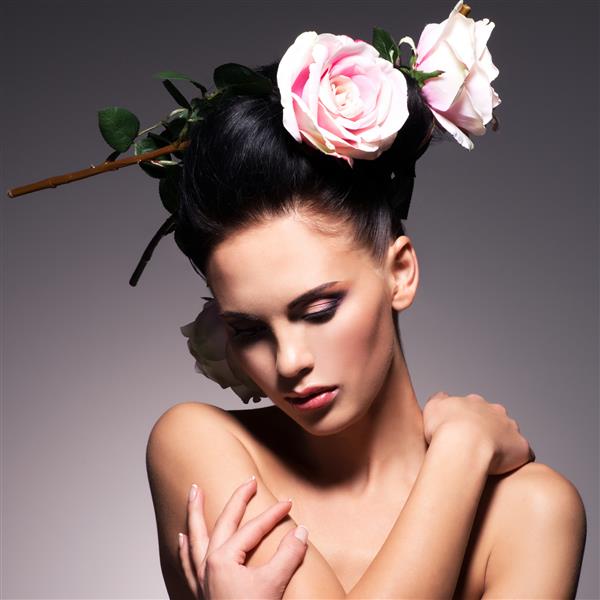 پرتره زن جوان زیبا با گل در حالت مو