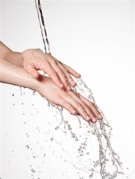 دست های زن نزدیک زیر جریان آب پاشیده - مفهوم مراقبت از پوست