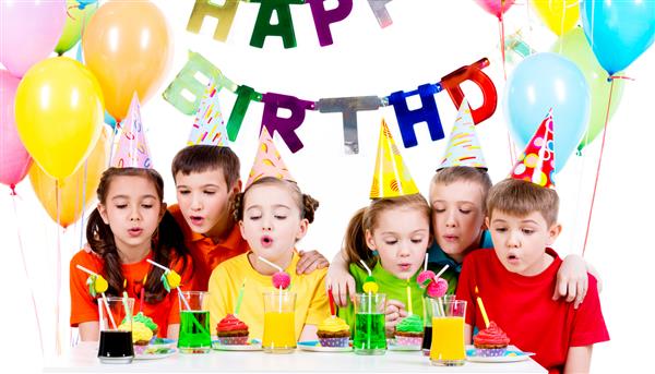 گروهی از بچه ها با پیراهن های رنگارنگ در حال دمیدن شمع در جشن تولد - جدا شده روی یک سفید