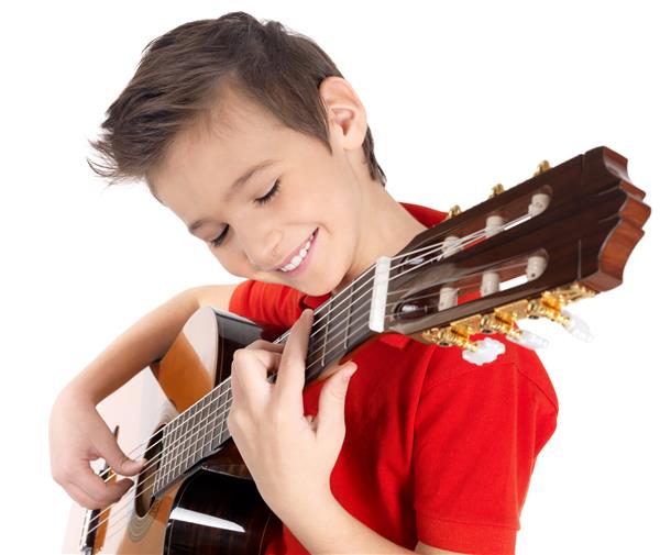 پسر قفقازی خندان با گیتار آکوستیک می نوازد - جدا شده روی دیوار سفید