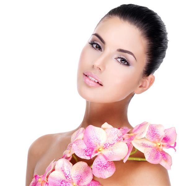 چهره زیبای زن جوان زیبا با پوست سالم و گل های صورتی روی بدن - جدا شده روی سفید