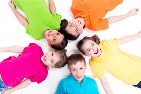 پنج کودک خندان با تی شرت های روشن روی زمین دراز کشیده اند نمای بالا جدا شده روی سفید