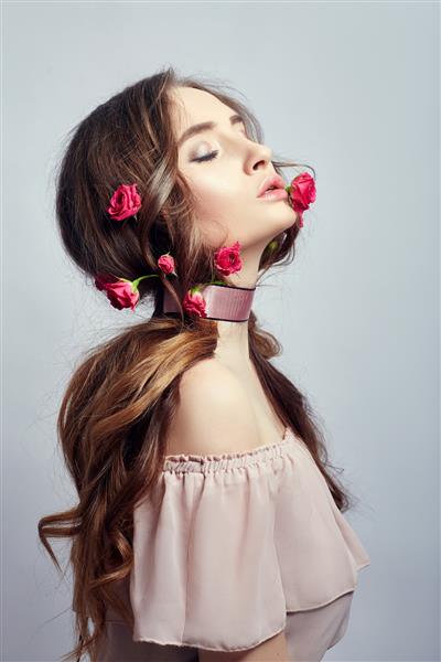 زن زیبا با گل های رز در موهای بلندش بانداژ دور گردنش تمیز کردن پوست صورت زیبا
