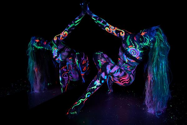 هنر بدن زن هنری روی بدن در حال رقصیدن در نور فرابنفش نقاشی های انتزاعی روشن روی رنگ نئون بدن زن مو و صورت رنگ شده