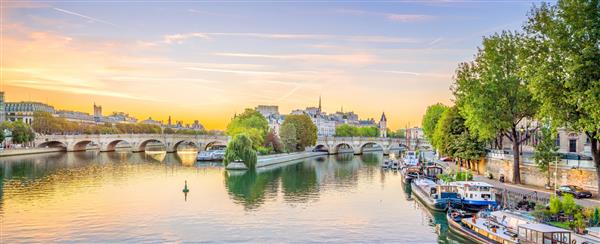 نمای طلوع خورشید از خط افق شهر قدیمی و رودخانه سن در پاریس فرانسه