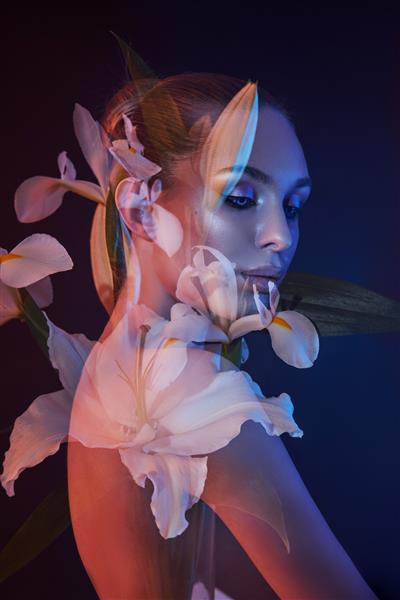 گل های زیبایی چهره یک زن با نوردهی دوگانه پرتره یک دختر با نور و رنگ نئون آرایش حرفه ای پشت برهنه یک زن گل در سر