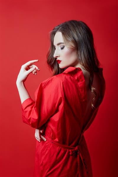 زن رمانتیک با موهای بلوند بلند در لباس قرمز پوست صاف و تمیز