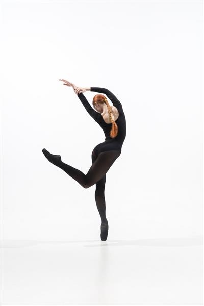 رقصنده جوان و برازنده باله به سبک سیاه مینیمال که در استودیو سفید جدا شده است