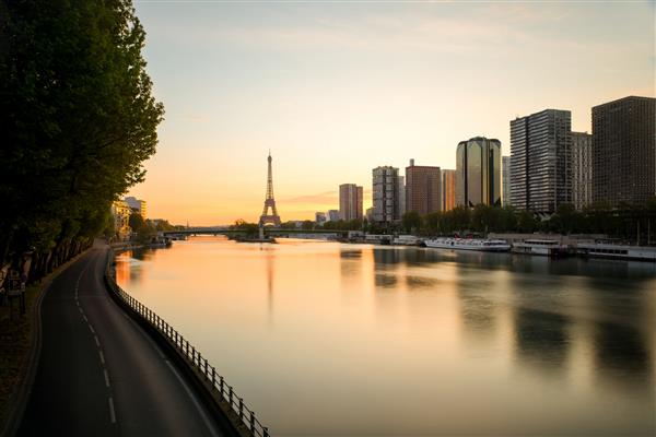 خط افق پاریس با برج ایفل و رودخانه سن در پاریس فرانسه طلوع زیبای خورشید در پاریس فرانسه