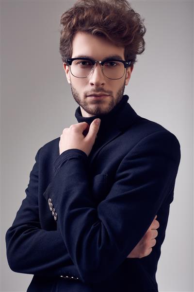 مرد خوش تیپ با موهای مجعد کت و شلوار و عینک