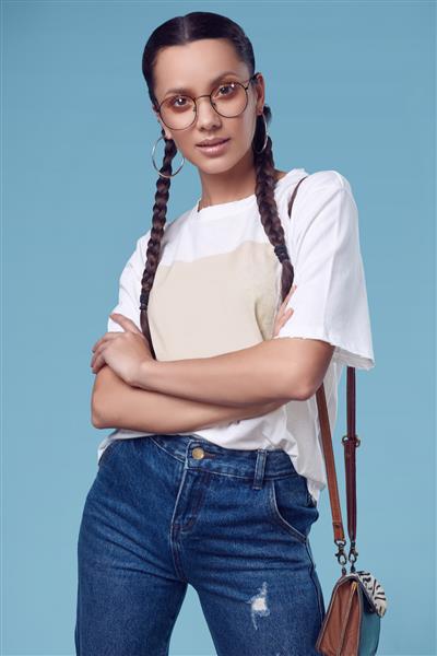 دختر اسپانیایی جذاب و جذاب با تی شرت سفید شلوار جین و عینک