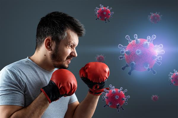 یک بوکسور مرد دستکش با ذرات ویروس کرونا کووید 19 مبارزه می کند مفهوم بیماری همه گیر واکسن