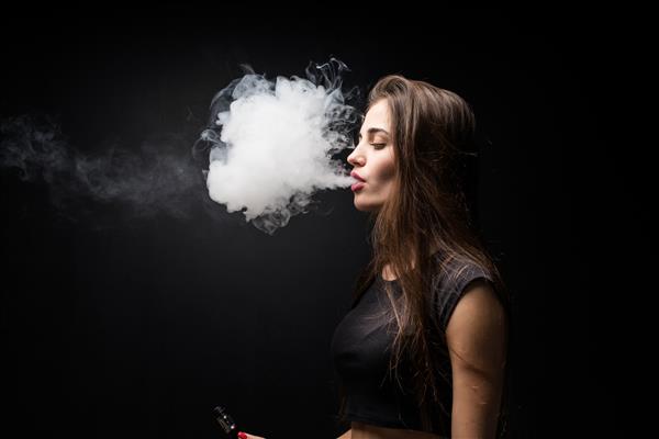 دختر با لباس سیاه در حال کشیدن سیگار الکترونیکی