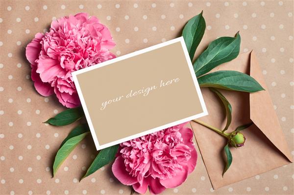 ماکت کارت تبریک با پاکت نامه و گل های گل صد تومانی صورتی در زمینه کاغذ کاردستی