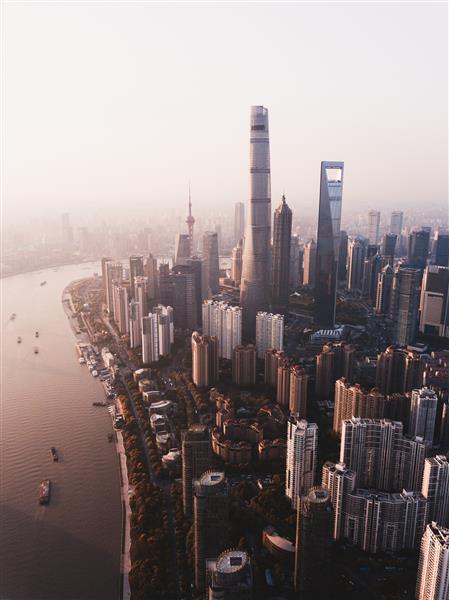 عکس بالای سر زیبا از خط افق شهر شانگهای با آسمان خراش های بلند و رودخانه در کنار