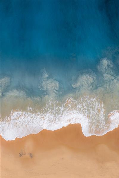 عکس بالای سر عمودی از یک دریای مواج در برابر ساحل دریا