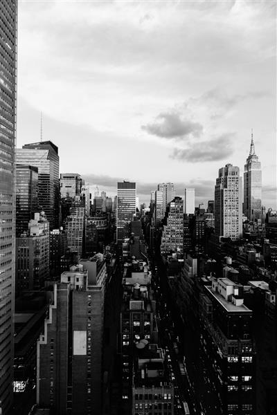 تصویری در مقیاس خاکستری عمودی از ساختمان‌ها و آسمان‌خراش‌ها در شهر نیویورک ایالات متحده آمریکا