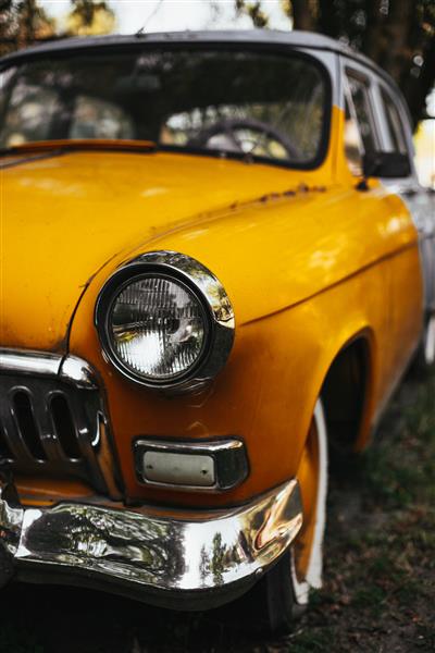 عکس عمودی از یک ماشین قدیمی زرد رنگ