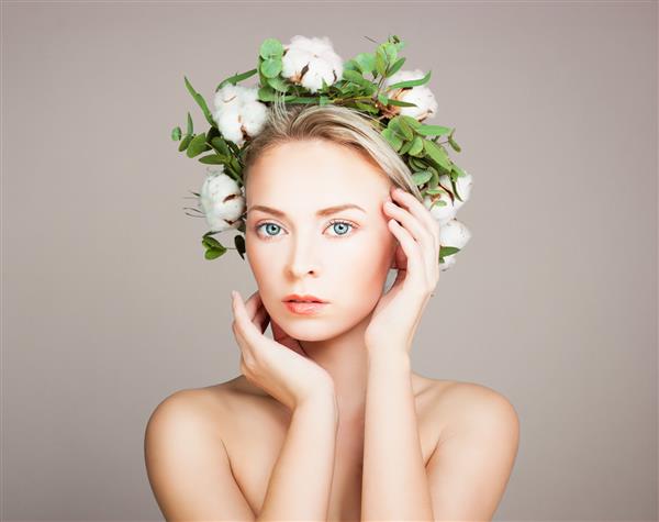 زن مدل ایده آل با پوست سالم و گل های نخی مفهوم زیبایی و درمان گیاهی