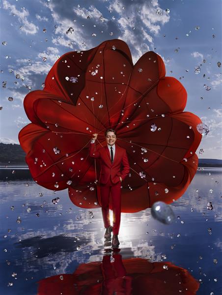 مرد زیبا با چتر نجات قرمز در بالای دریاچه