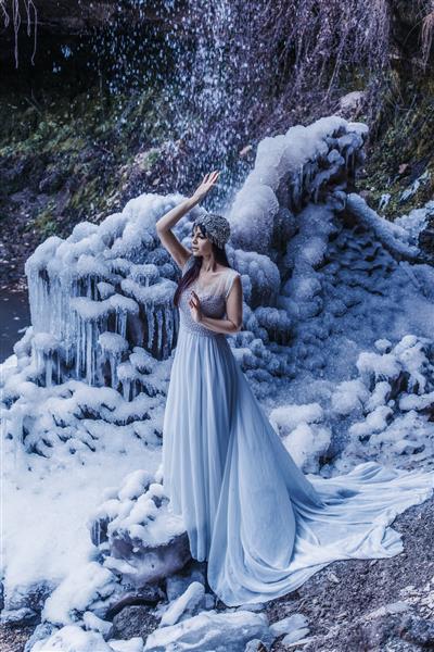 زن زیبا با آبشار یخی یخ زده
