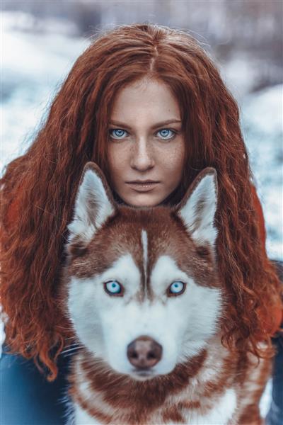 زن مو قرمز زیبا در برف با هاسکی قرمز
