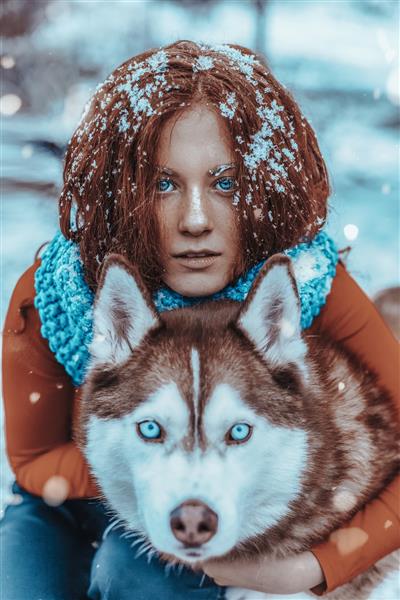زن مو قرمز زیبا در برف با هاسکی قرمز