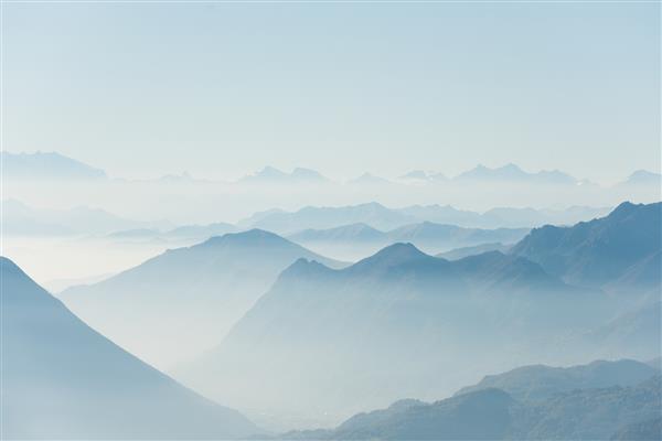 تصویری زیبا از تپه‌های بلند سفید و کوه‌های پوشیده از مه