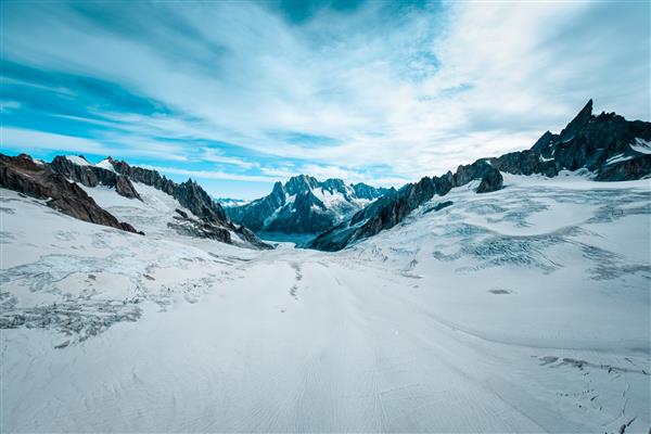عکس وسیع زیبا از یخچال های طبیعی روت پوشیده از برف در زیر آسمان آبی با ابرهای سفید