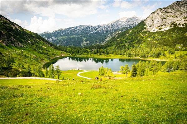 مناظر زیبا از یک دره سبز در نزدیکی کوه های آلپ در اتریش زیر آسمان ابری