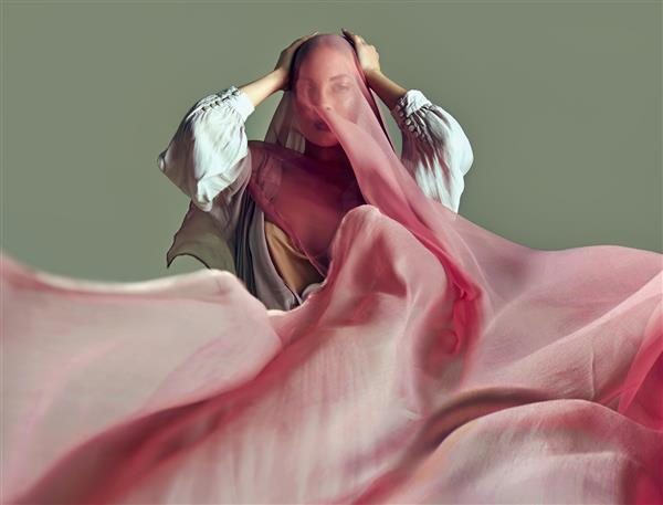 یک دختر جوان زیبا با لباس نوعی پارچه ابریشمی با پارچه ای ساخته شده از پارچه نازک پوشیده شده است که در باد ایجاد می شود مد زیبایی آرایش لوازم آرایشی سالن زیبایی استایل مراقبت شخصی