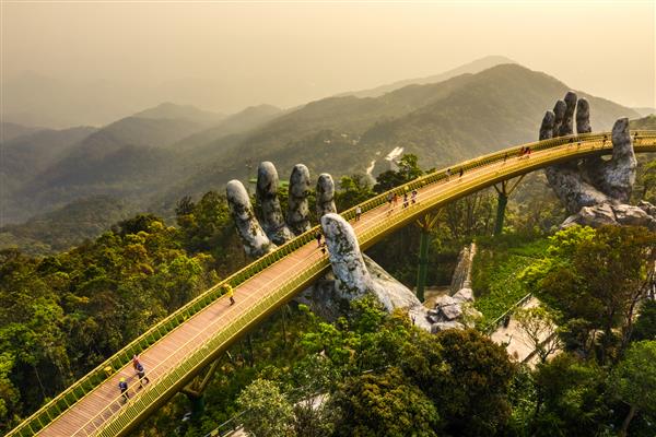 نمای هوایی از پل معروف طلایی توسط دو دست غول پیکر در تفرجگاه توریستی در تپه با نا در دا نانگ ویتنام بلند شده است Cau Vang مقصد مورد علاقه گردشگران است