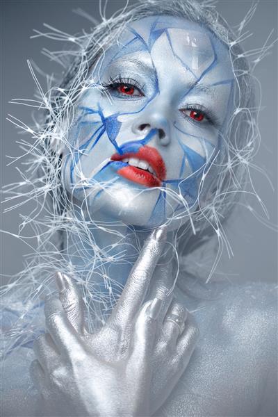 دختر زیبا در ظاهر غیر معمول زمستانی با لب های قرمز آرایش خلاقانه نگاه هنری عکس گرفته شده در آتلیه