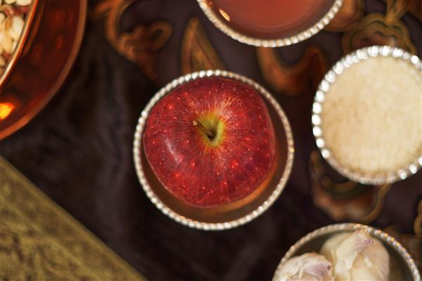 یک سیب در بشقاب کوپر شده برای هفت سین یا نوروز یک ضیافت سنتی ایرانی