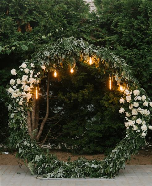 طاق عروسی زیبا با چراغ های رترو تزئین شده با گل های شب محل پذیرایی شب عروسی ها