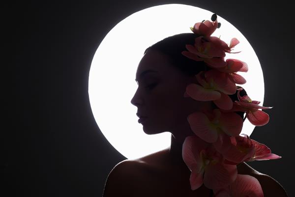 زن جوان زیبا با گل ارکیده شبح زنانه با گل