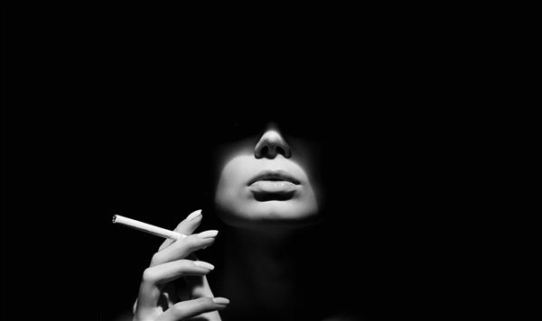 زن زیبا با یک سیگار در تاریکی پرتره سیاه و سفید