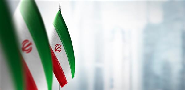 پرچم های کوچک ایران در پس زمینه ای مبهم از شهر