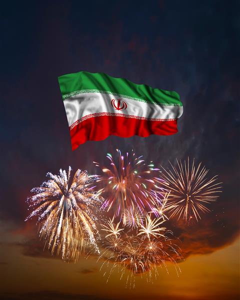 آتش بازی تعطیلات در آسمان عصر و پرچم ایران به مناسبت روز استقلال ملی دهه فجر