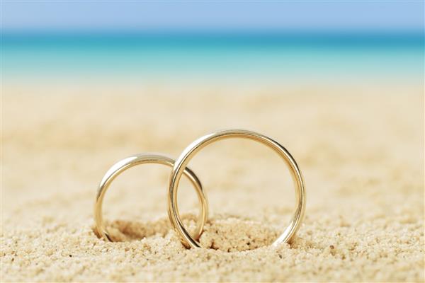 عکس حلقه ازدواج روی شن و ماسه در ساحل