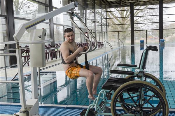 مرد معلول در یک استخر شنا ویلچر معلول روی ویلچر