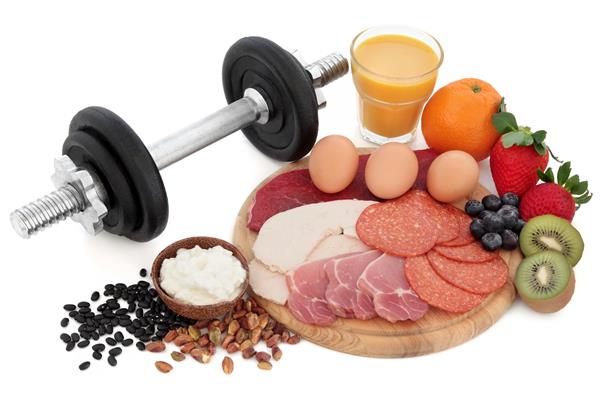 سلامتی و بدن سازی غذای پروتئینی بالا شامل گوشت آجیل حبوبات پنیر میوه و آب اسموتی با وزنه های دمبل روی زمینه سفید