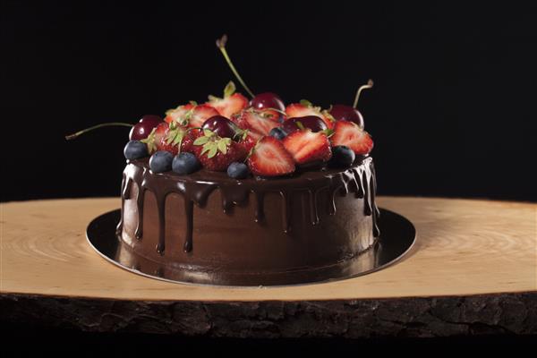کیک شکلاتی با انواع توت ها با پس زمینه زیبایی