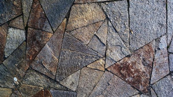الگوی سنگ های مثلثی الگوی زمین سنگی الگوی بدون درز سنگ های تیره گرانیت الگوی هندسی پیاده رو سنگی